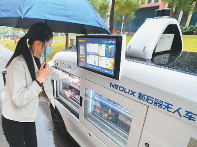 在湖南省检验检测特色产业园内，市民通过无人零售车购买商品。新华社记者 陈泽国摄